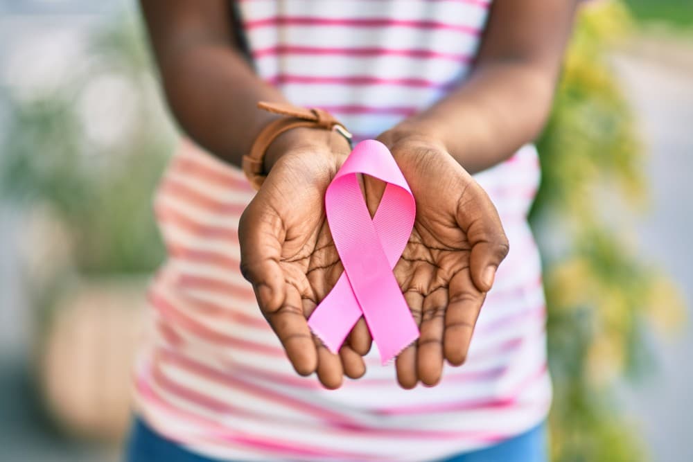 Hands holding cancer ribbon to represent breast cancer