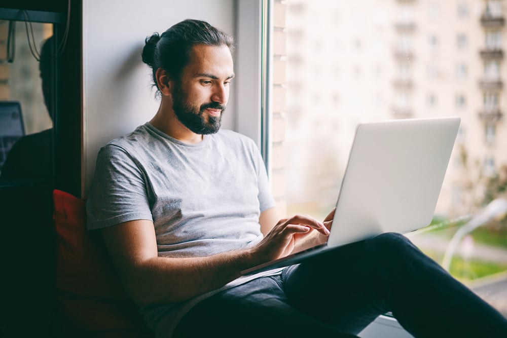 Man sat reading about men's health on his laptop